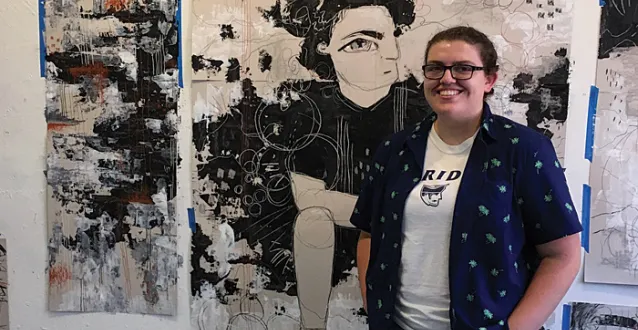 Hailey Bennett standing by her artwork in NYC