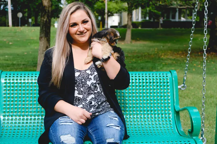 Hannah Garofalo with her puppy sitting on a bench