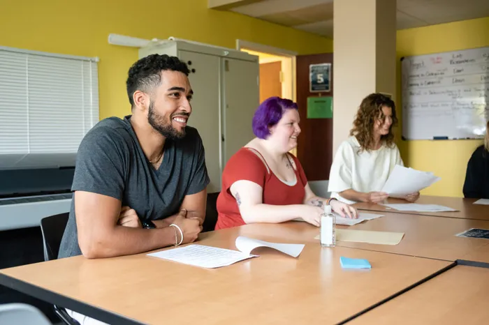 Students seated at a table, smiling