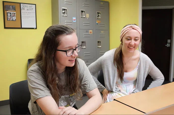 Students smiling, sitting at a table