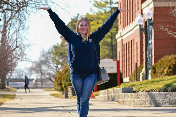 Female student with hands in the air