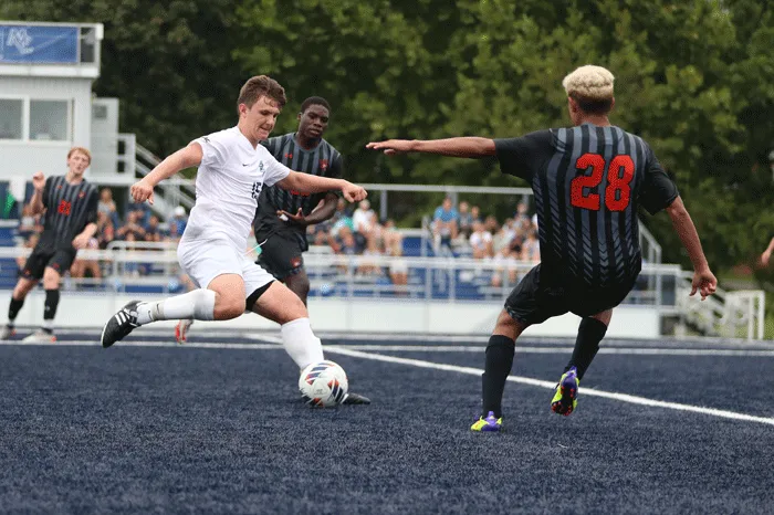 Soccer player moving between two defenders