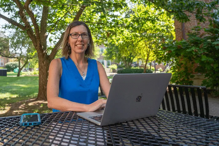 Nicole Livengood sitting outside with a laptop