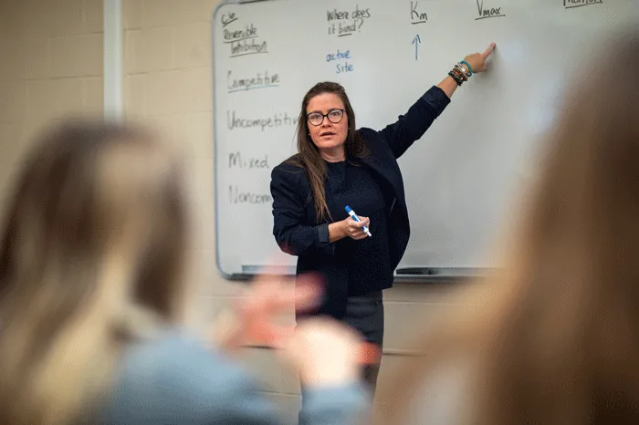 Professor teaching from a white board