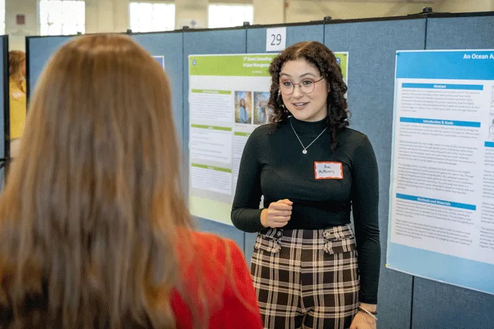 Student presenting poster at All Scholars Day