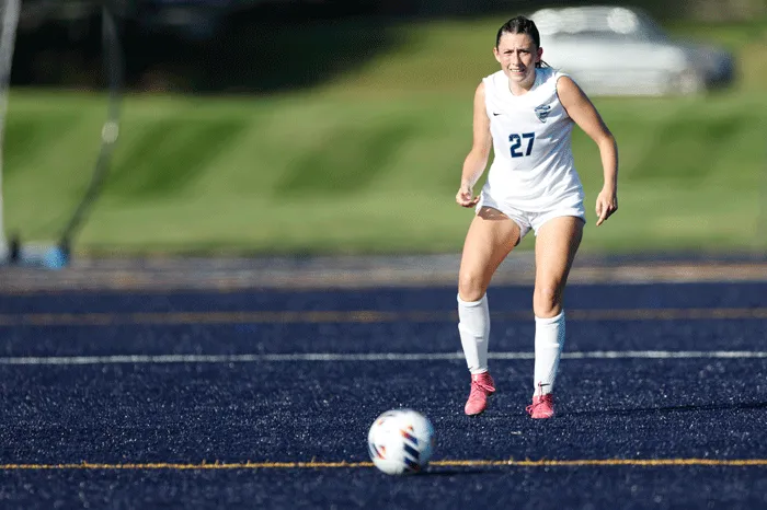 Women's soccer player prepares to kick the ball