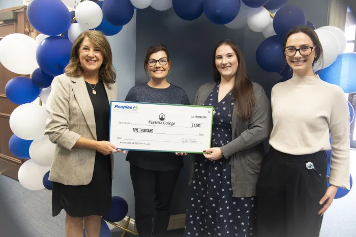 Peoples Bank representatives Staci Matheney and Tori Tadlock present Dr. Amy Elliott and Shannan Tschopp a $5,000 check