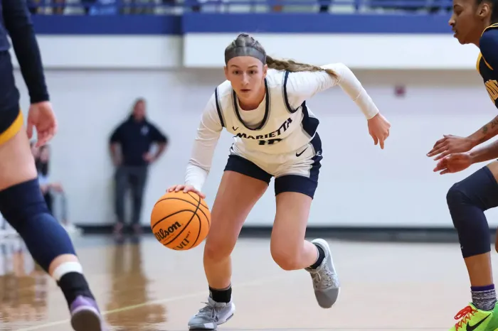 Adi Hill dribbling between two defenders