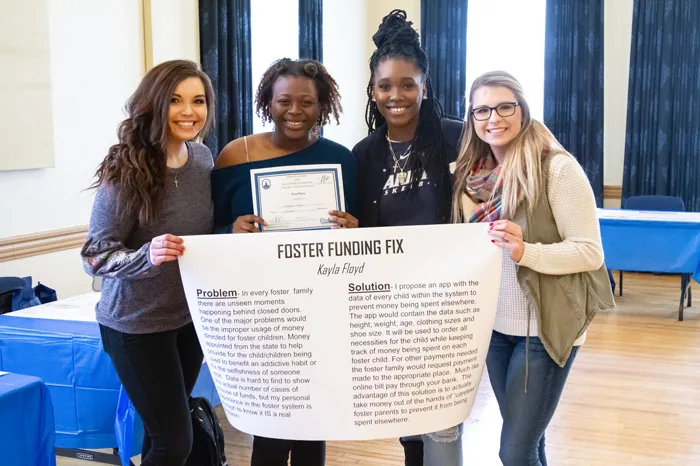 Students holding up a poster from Junior PioBiz