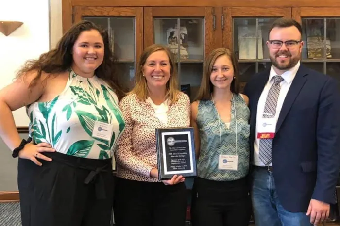 Students and faculty holding an award