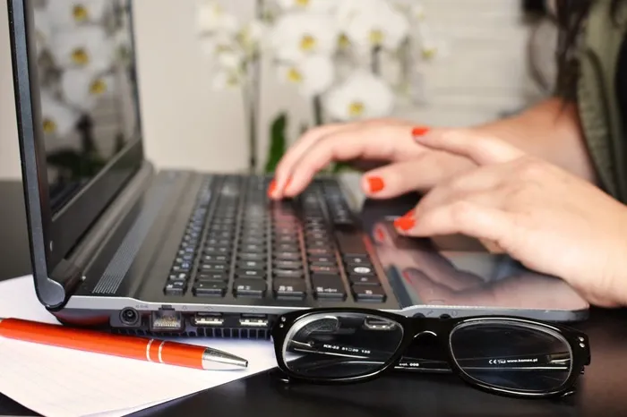 Hands typing on a computer