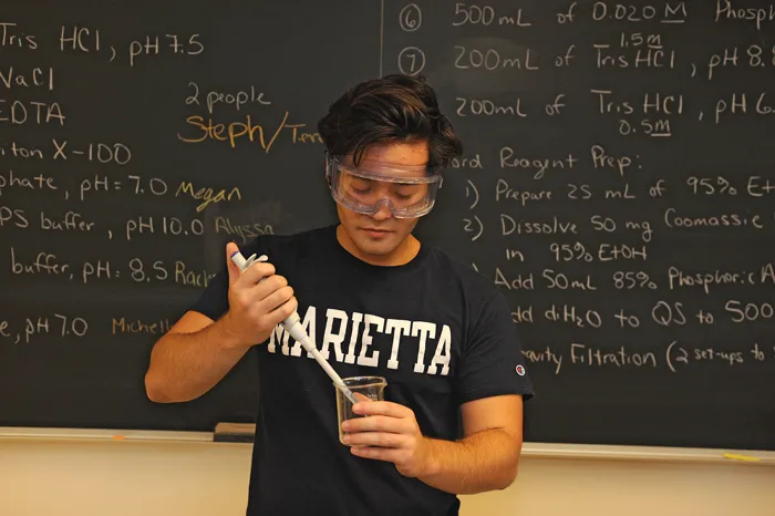 STEM student in front of a chalk board