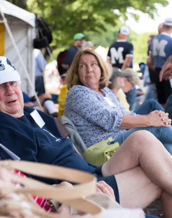 Crew Alumni Sit on the river bank to watch MC's crew team at the Dad Vale