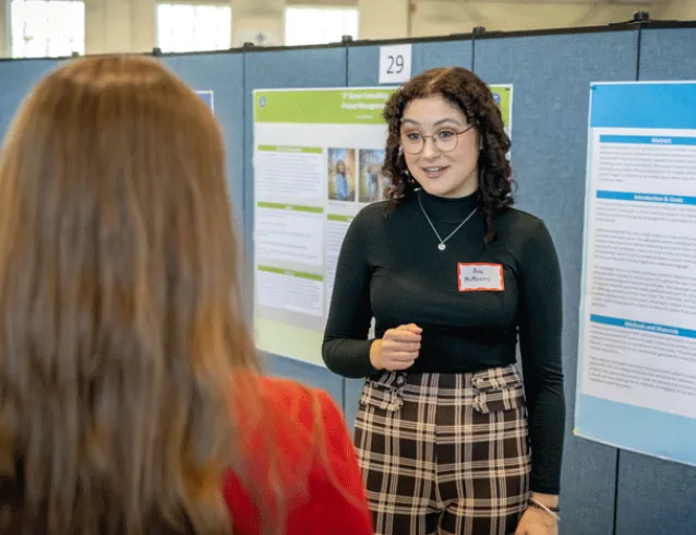 Student presenting poster at All Scholars Day