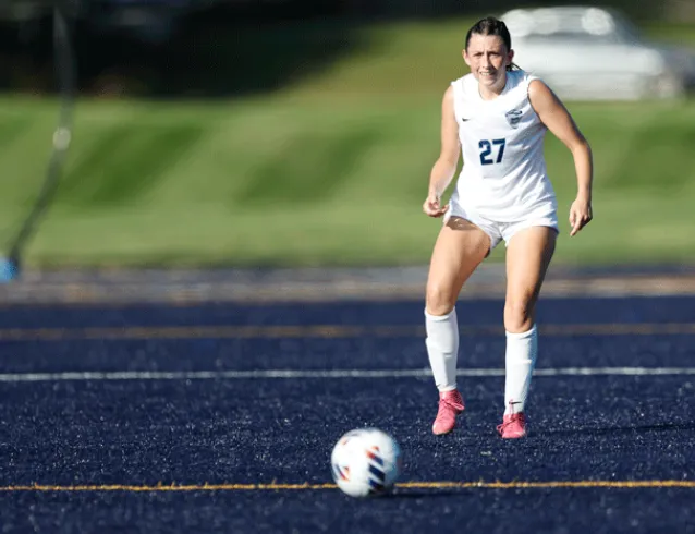 Women's soccer player prepares to kick the ball