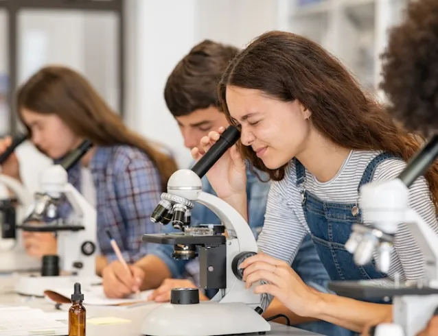 student using a microscope