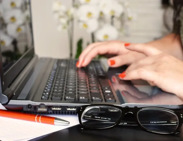 Hands typing on a computer