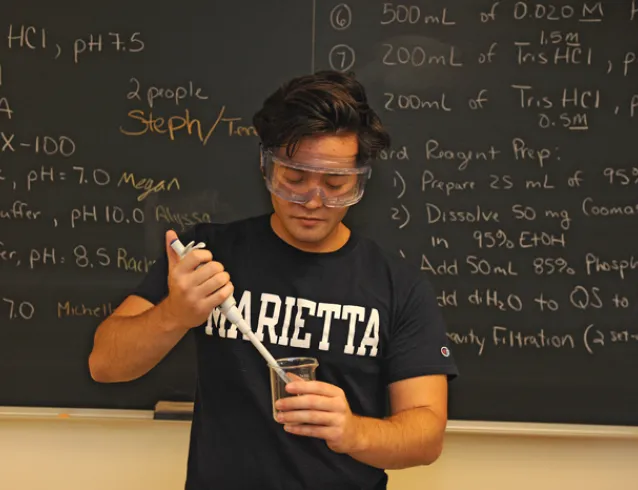 STEM student in front of a chalk board