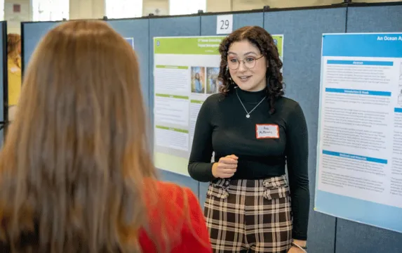 Student presenting poster at All Scholars Day