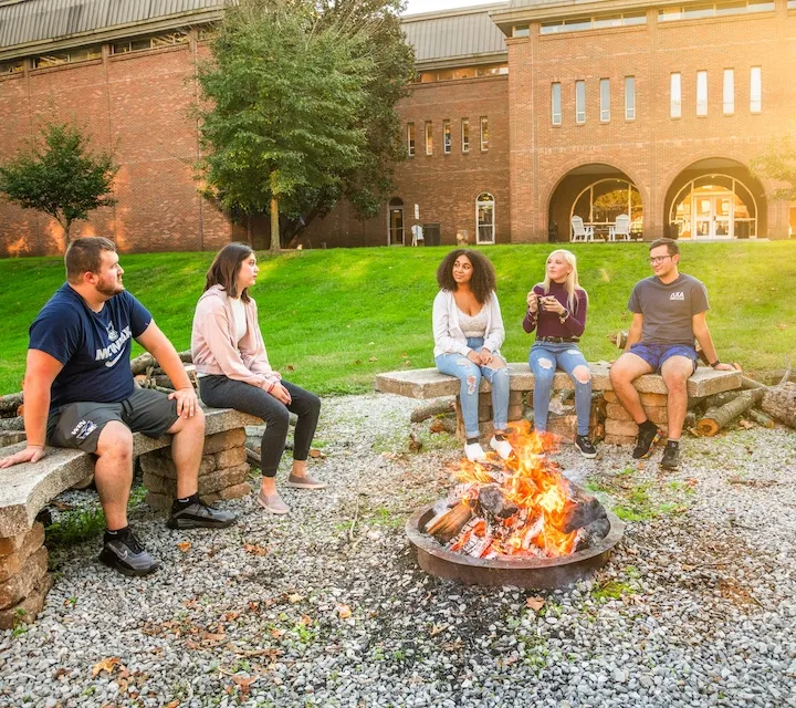 students sitting around a fire