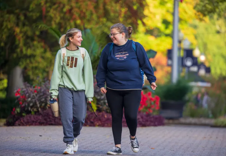 Two female students walking on The Christy Mall