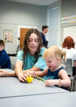 A Marietta College Teacher Education major sits with a student