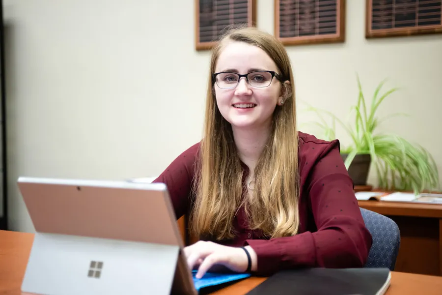 Student smiling with a tablet in front of her